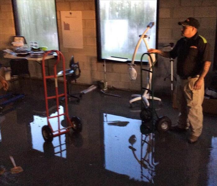 SERVPRO technician standing in water puddle in commerical room