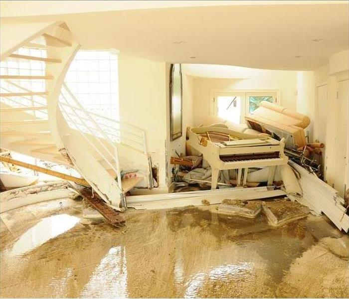 Flooded Home with piles of ruined furniture.